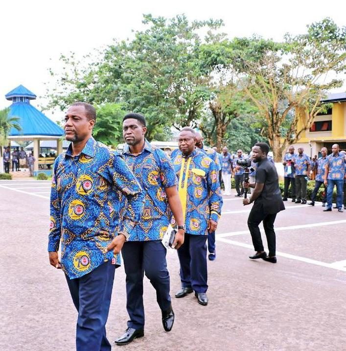 Akatakyie members in matching blue and gold print cloth walking through the Opoku Ware School campus